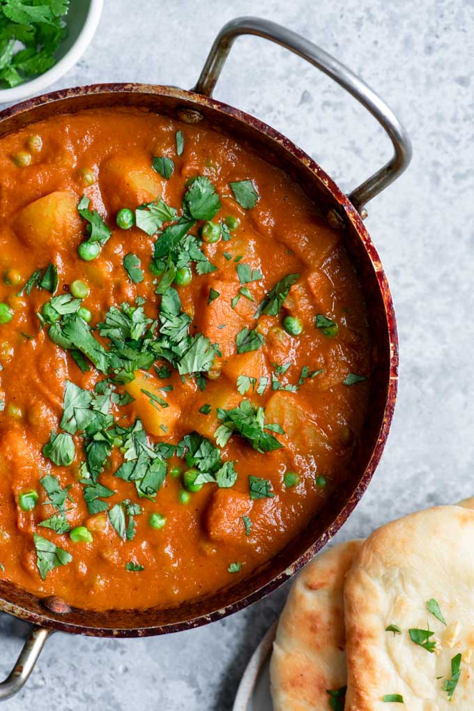 aloo matar topped with cilantro and served with a side of naan