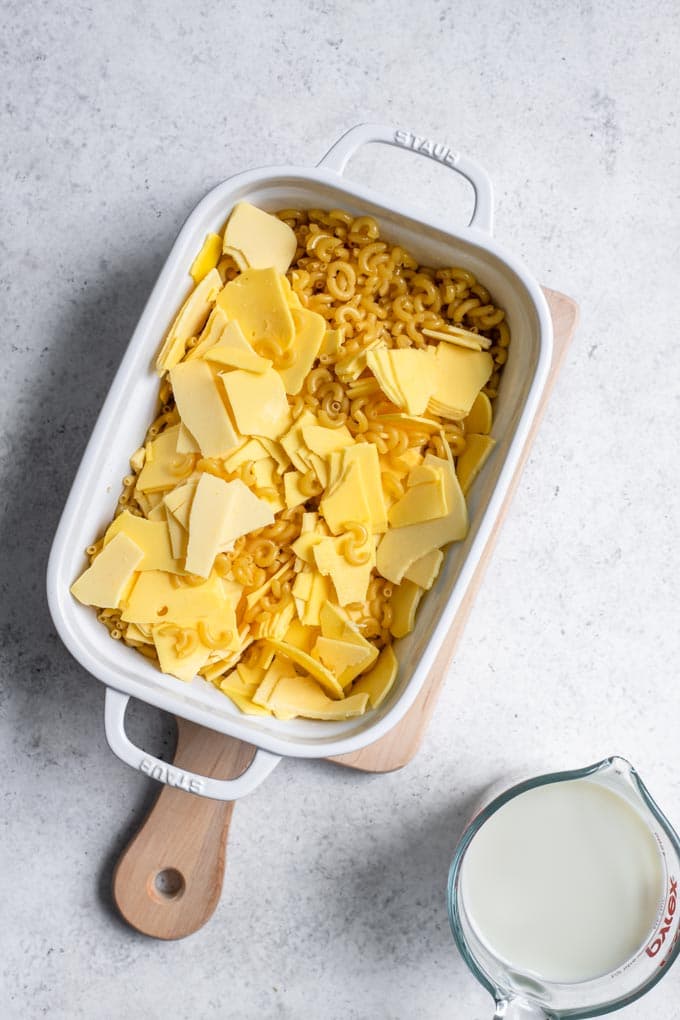 uncooked noodles and vegan cheese mixed together in pan for no boil mac and cheese