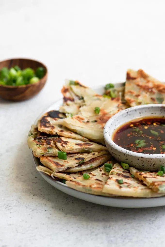 scallion pancakes on a plate with dipping sauce