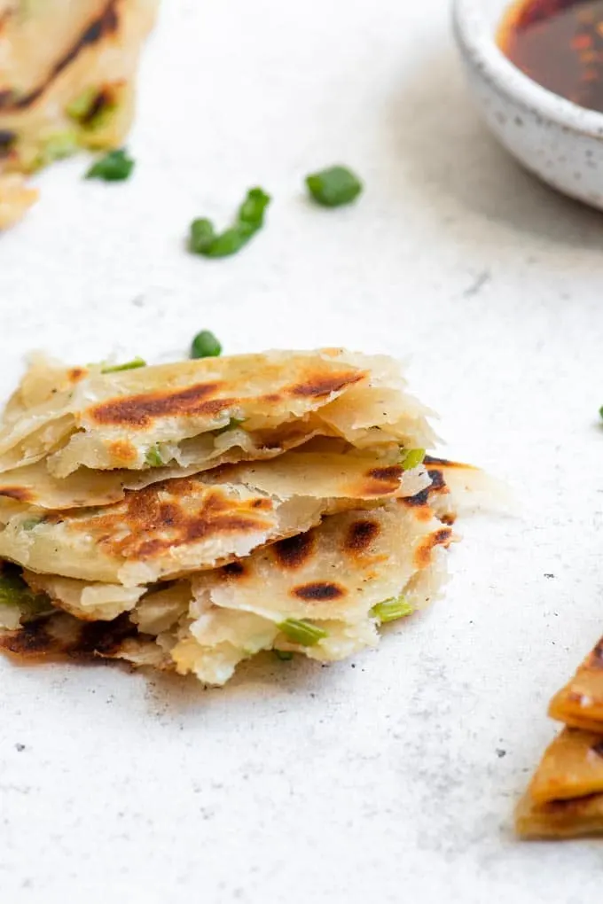 scallion pancake torn into pieces to show the flaky layers