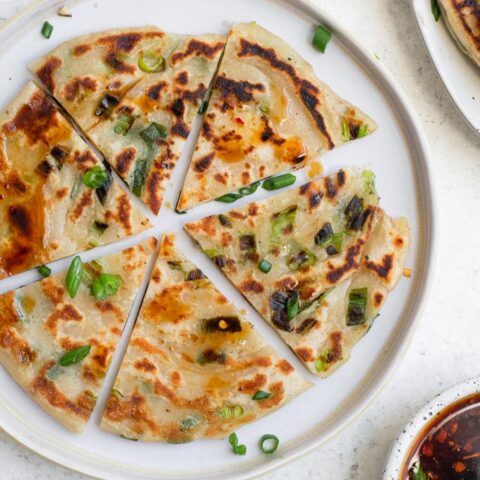 one scallion pancake cut into 6 wedges on a plate