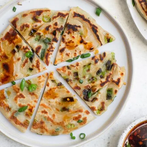 one scallion pancake cut into 6 wedges on a plate