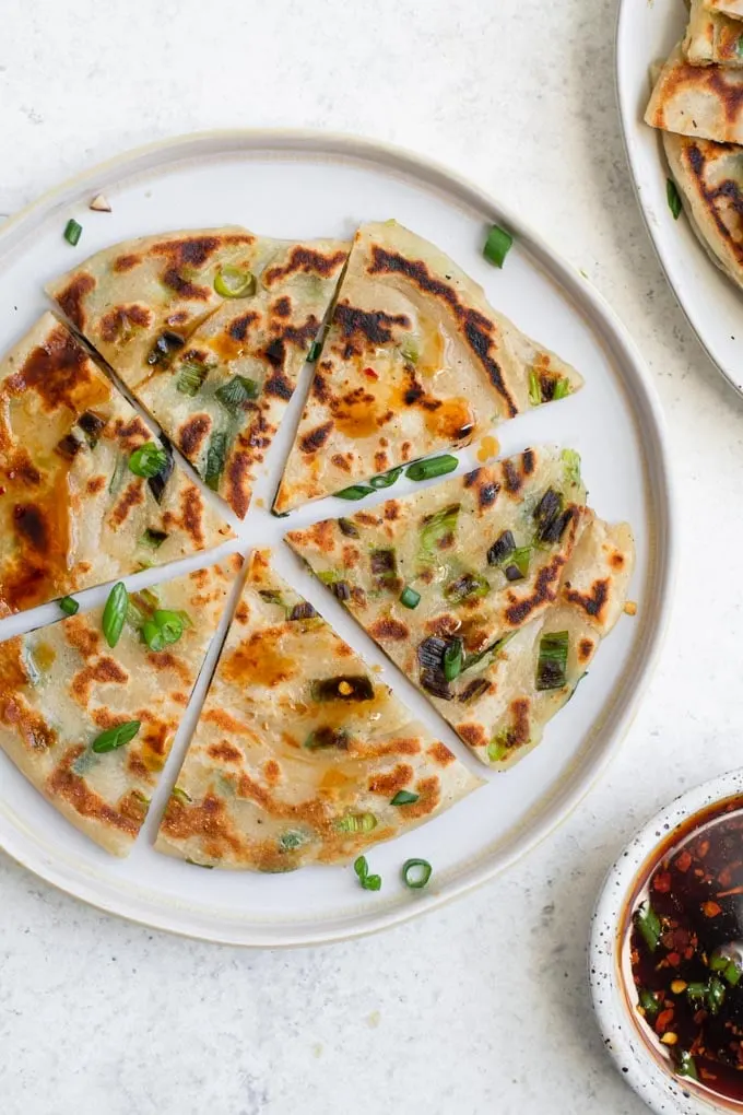 one scallion pancake cut into 6 wedges on a plate