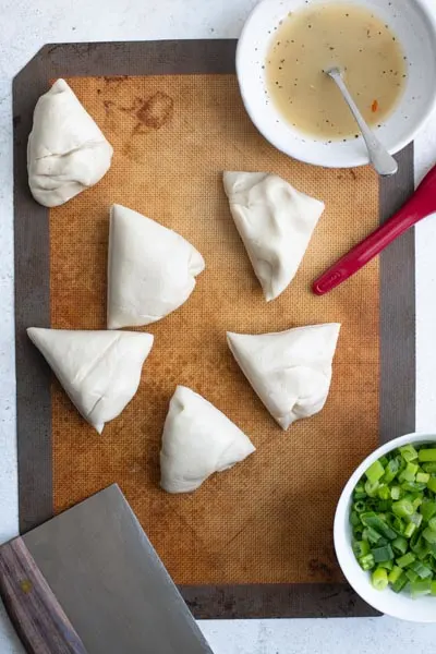 scallion dough cut into 6 pieces on a silicon mat