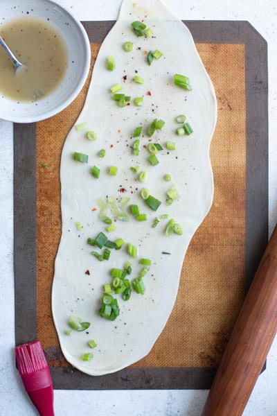 dough rolled and topped with scallions