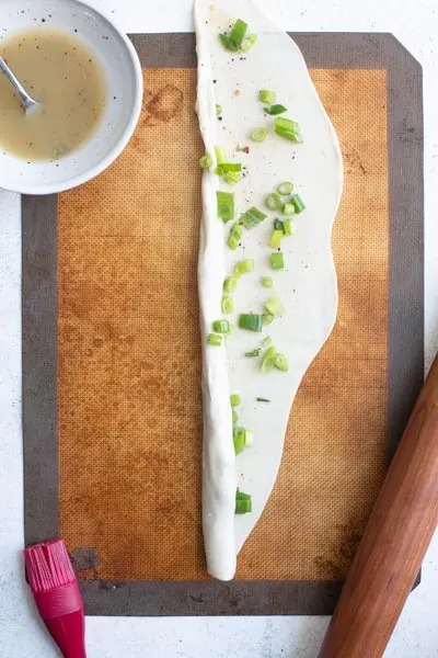 rolling the topped dough into a rope