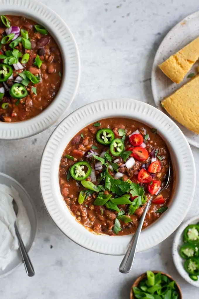 vegan chili with toppings and cornbread
