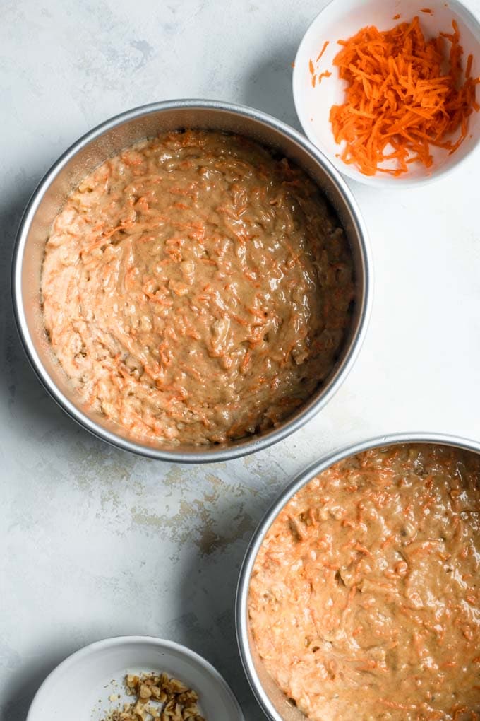 carrot cake batter divided into in baking tins