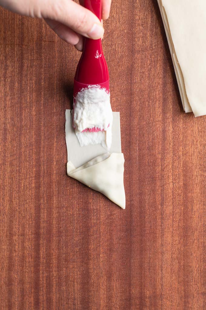 brushing samosa wrapper edge with flour water glue