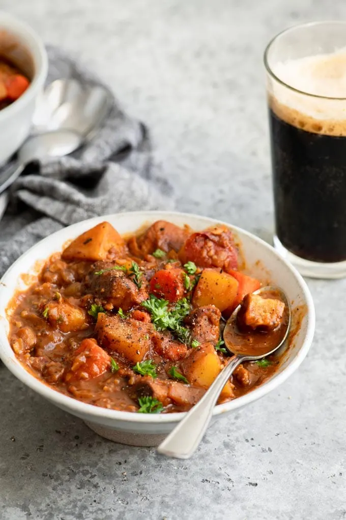 Bowl of vegan stew with pint of Guinness