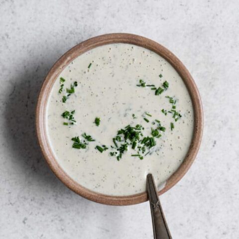cashew ranch dressing in a bowl with chives partially stirred in