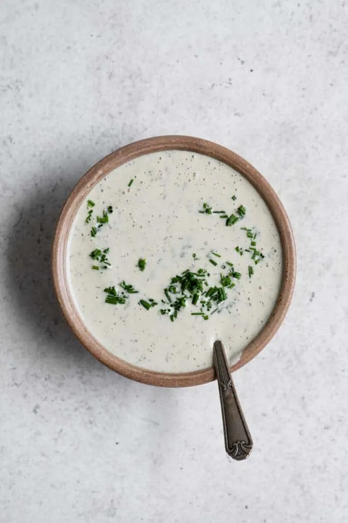 cashew ranch dressing in a bowl with chives partially stirred in