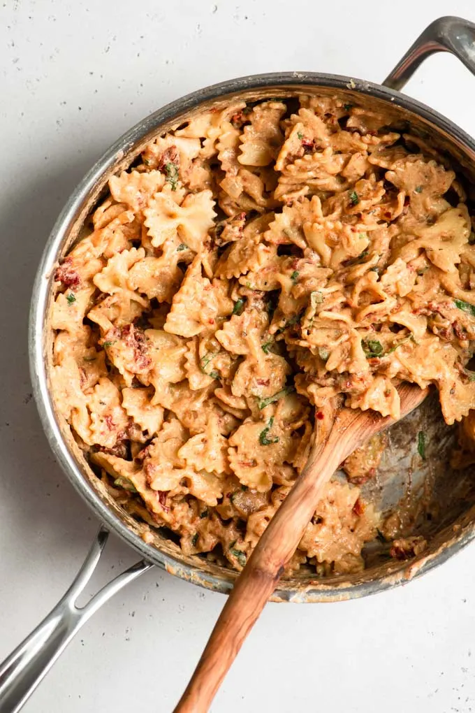 bowtie pasta tossed in sun dried tomato cream sauce in a pot