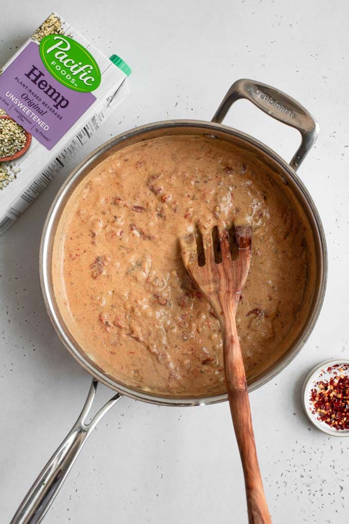 sun dried tomato cream sauce in pot with box of hemp milk in photo