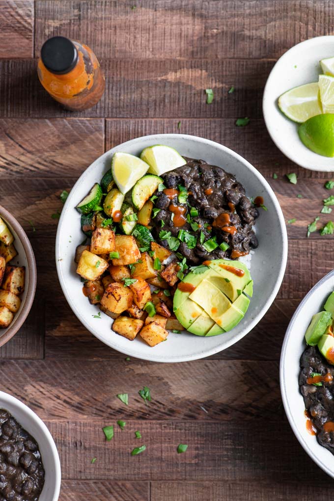 black bean burrito bowl with roasted potatoes, avocado, and zucchini