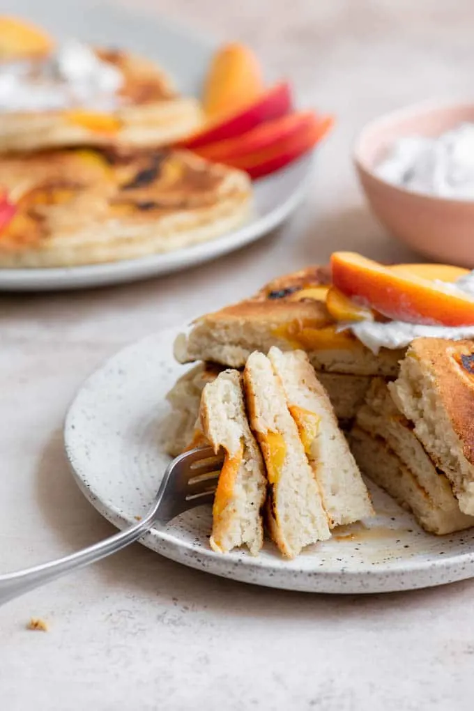 bite of pancake on fork, with cross section of peaches showing