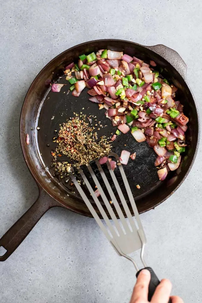 cooking spices in oil with onion mixture pushed to side of pan