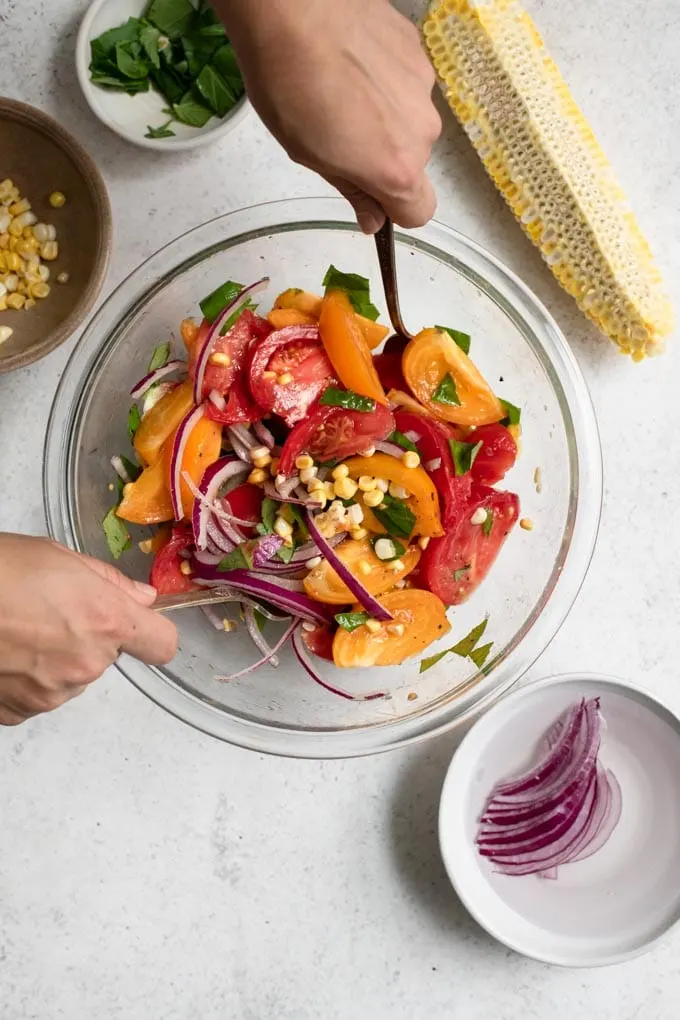 tossing the tomato corn salad