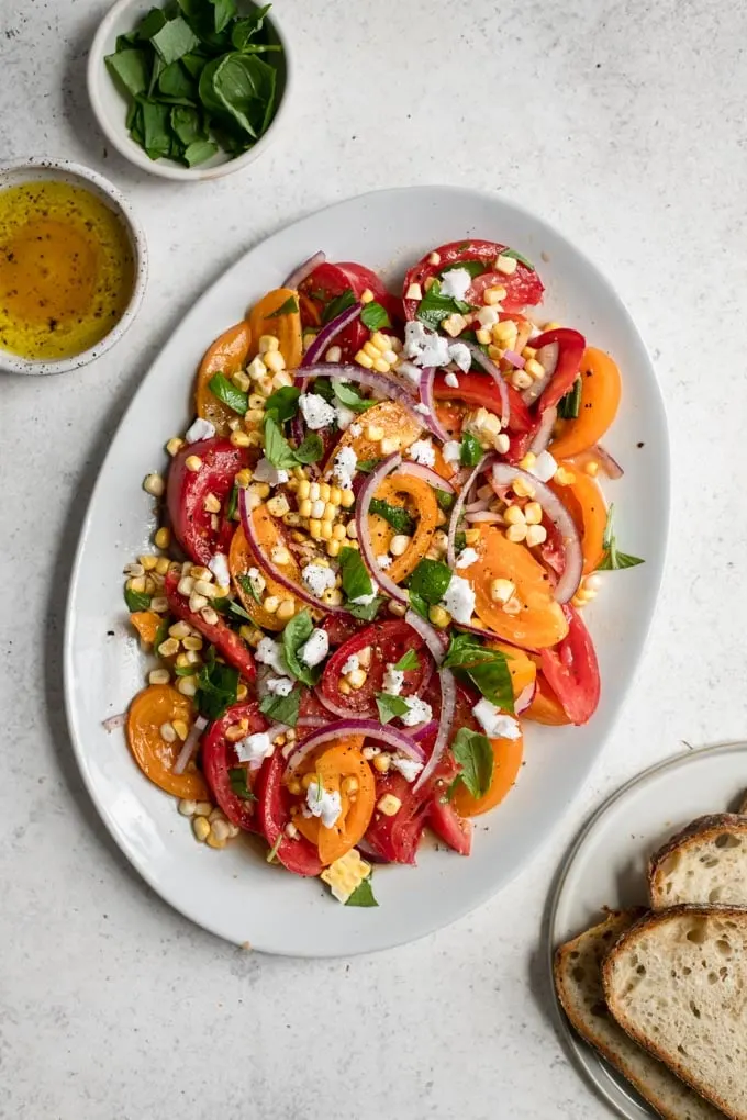 fresh tomato sweet corn salad served on oval plate