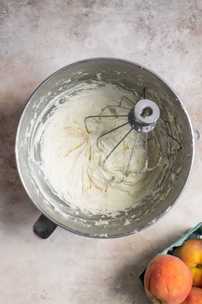 vegan peach buttercream in mixing bowl with balloon whisk