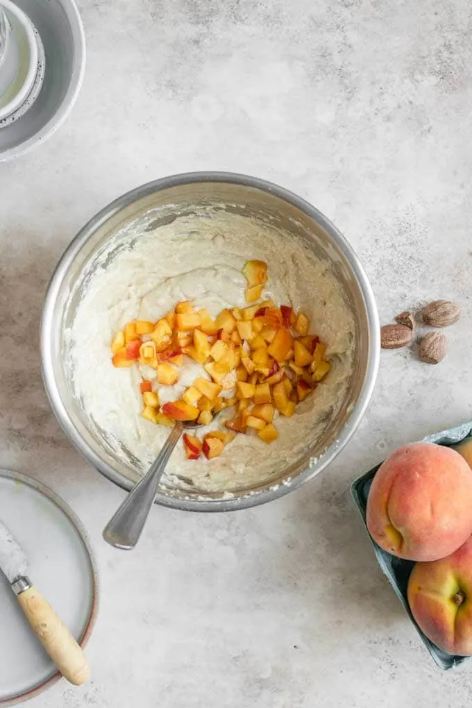 peaches being folded into cake batter