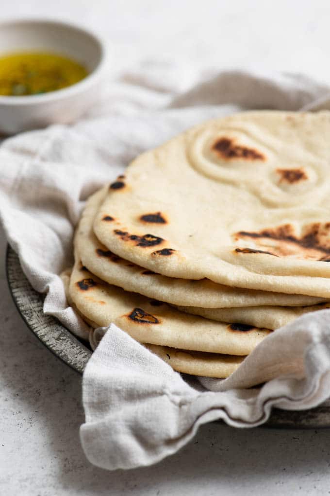 flatbreads stacked on a plate and wrapped in a napkin