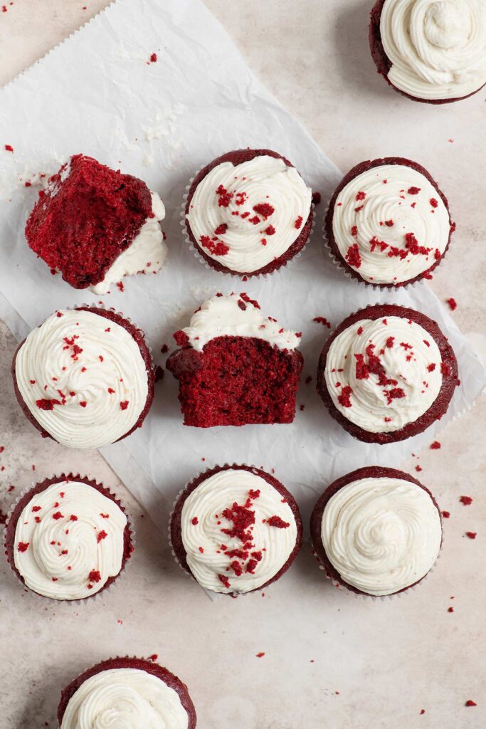 overhead view of 11 cupcakes with two turned on their sides with bites taken showing the crumb