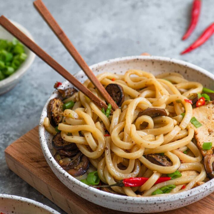 spicy sichuan noodles with eggplant in a bowl with wooden chopsticks
