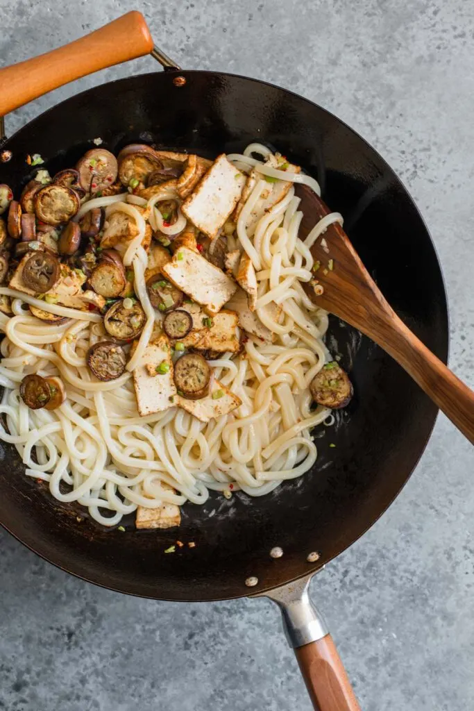 noodles, eggplant, and tofu added to wok