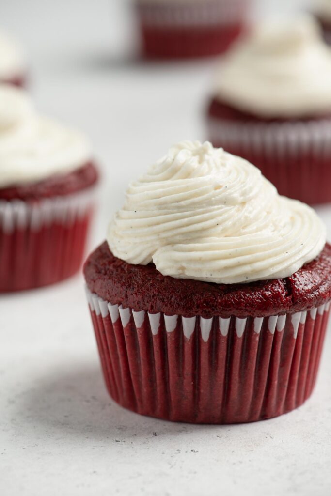 piped vegan ermine frosting on a red velvet cupcake