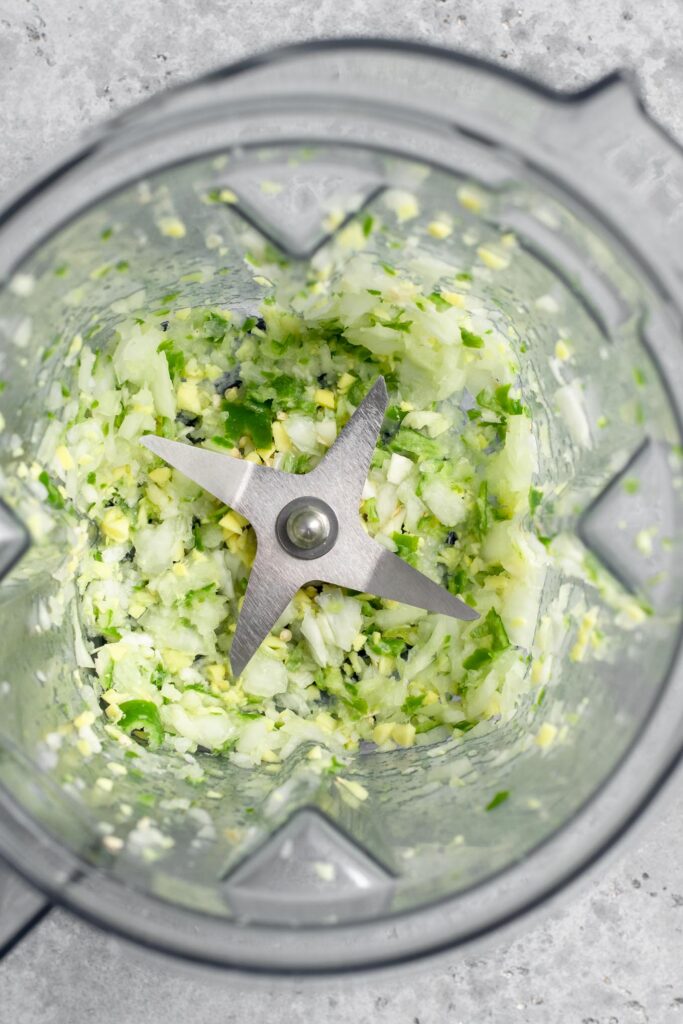 blending onion, ginger, garlic, and chilies together to mince them