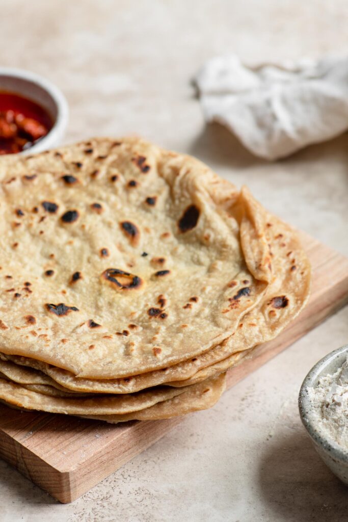 homemade roti stacked on cutting board