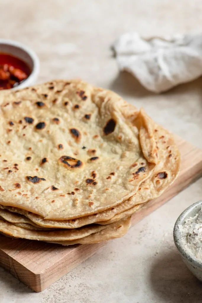 homemade roti stacked on cutting board