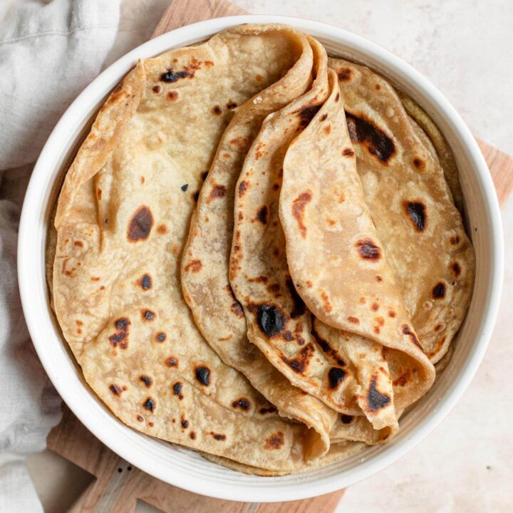 cooked roti with three folded partway over, stacked in tortilla warmer