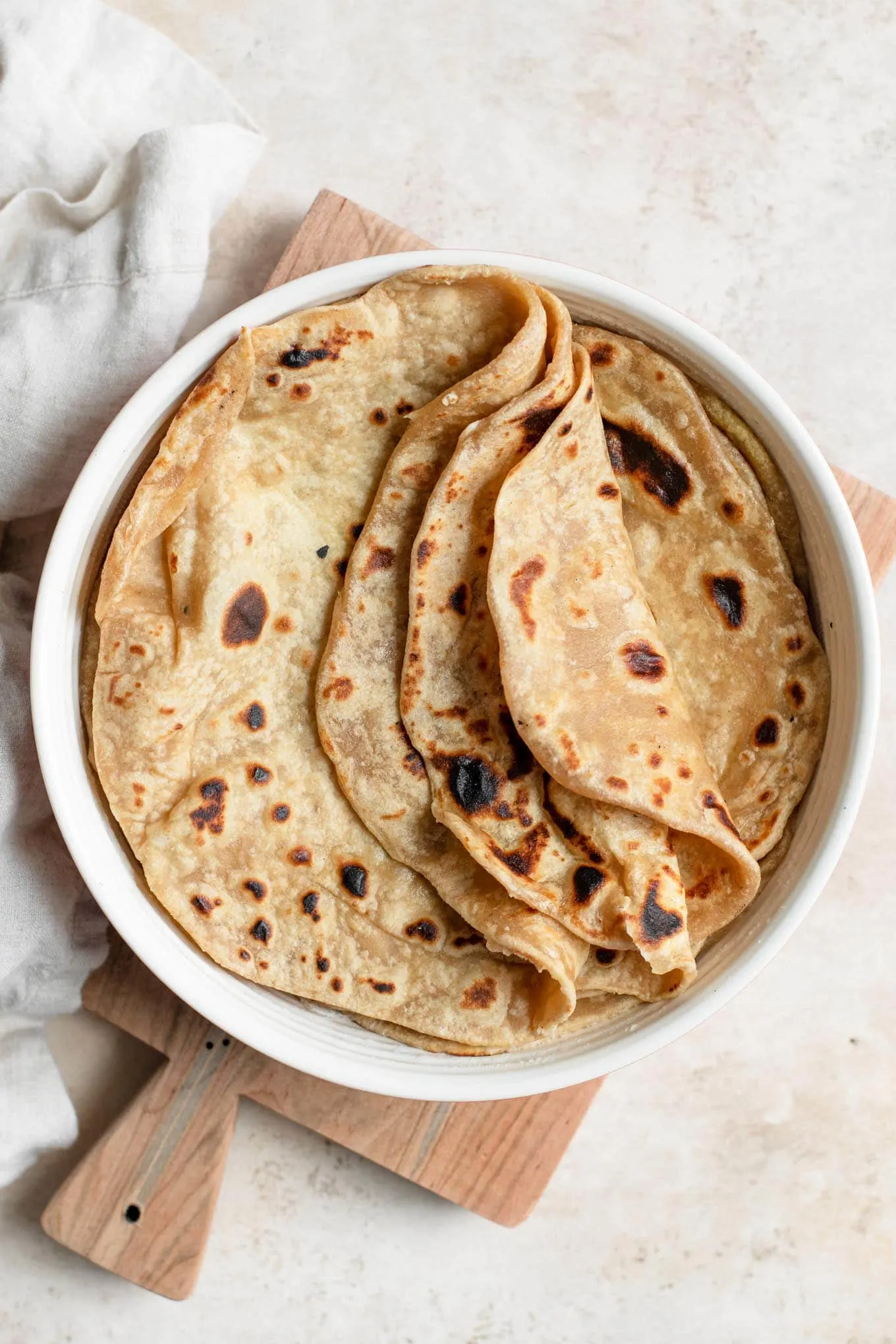 cooked roti with three folded partway over, stacked in tortilla warmer