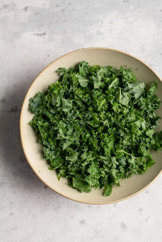 chopped kale in mixing bowl before massaging