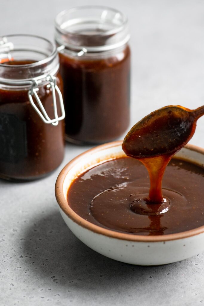 showing the consistency of the chutney by running it off a spoon into a bowl