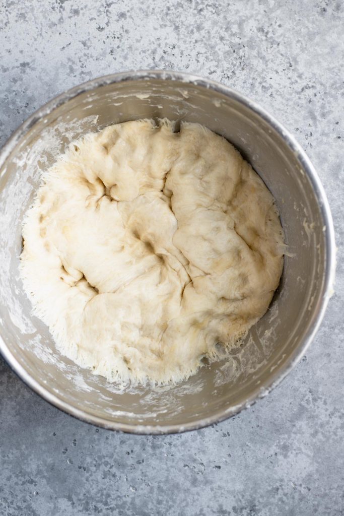 deep dish pizza dough punched down after rising