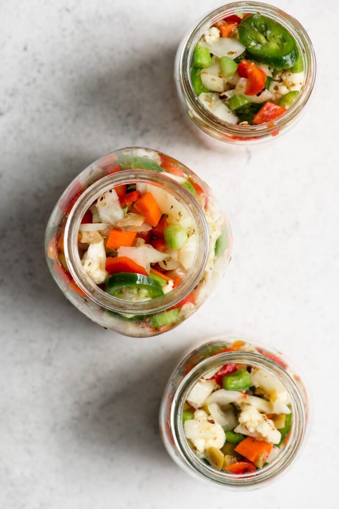 homemade giardiniera in three glass jars overhead view