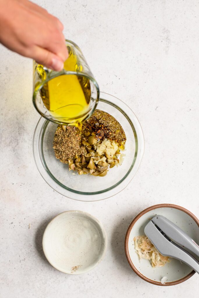 pouring the oil into the rest of the giardiniera dressing ingredients