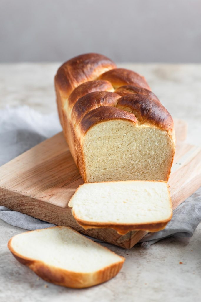 braided brioche loaf with two slices cut off