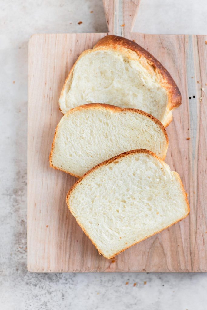 three slices of vegan brioche on a cutting board