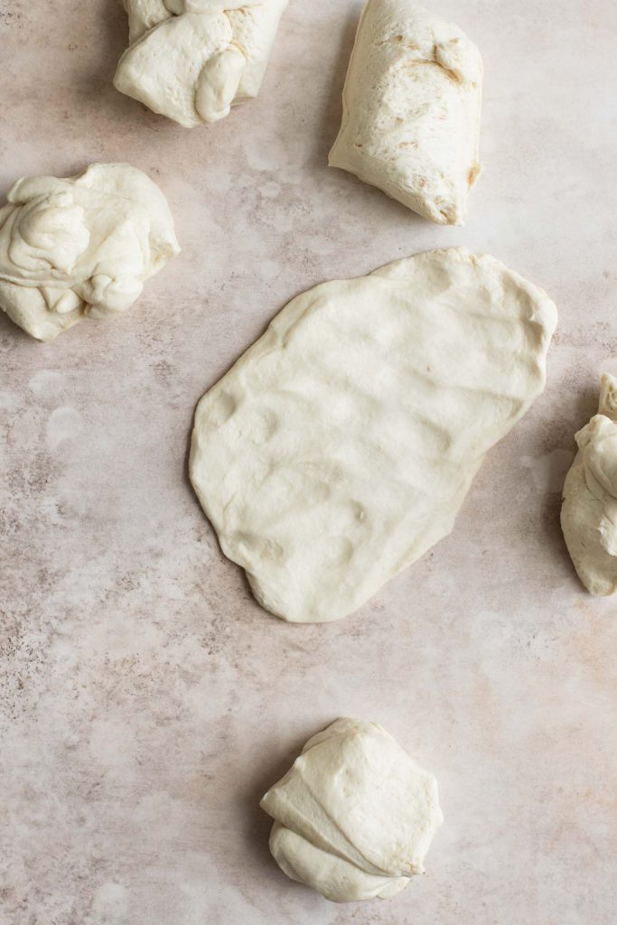 one segment of dough flattened into a rectangle