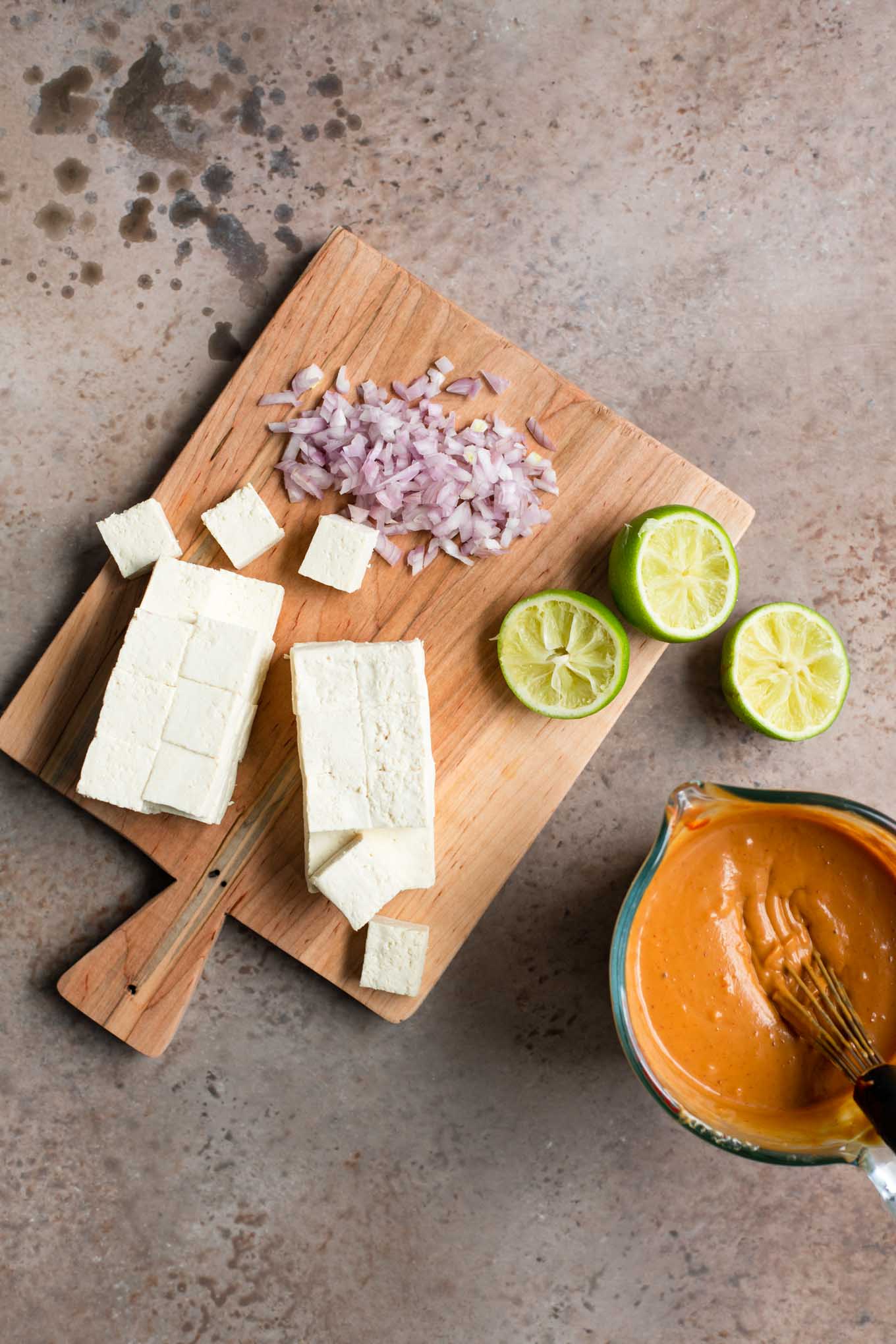 cubed tofu, minced shallot, squeezed lime halves, and peanut sauce