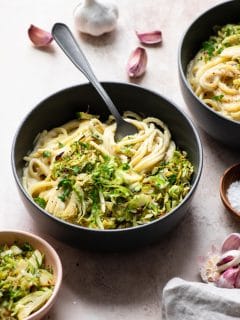 vegan creamy pasta topped with shaved brussels sprouts served in bowls