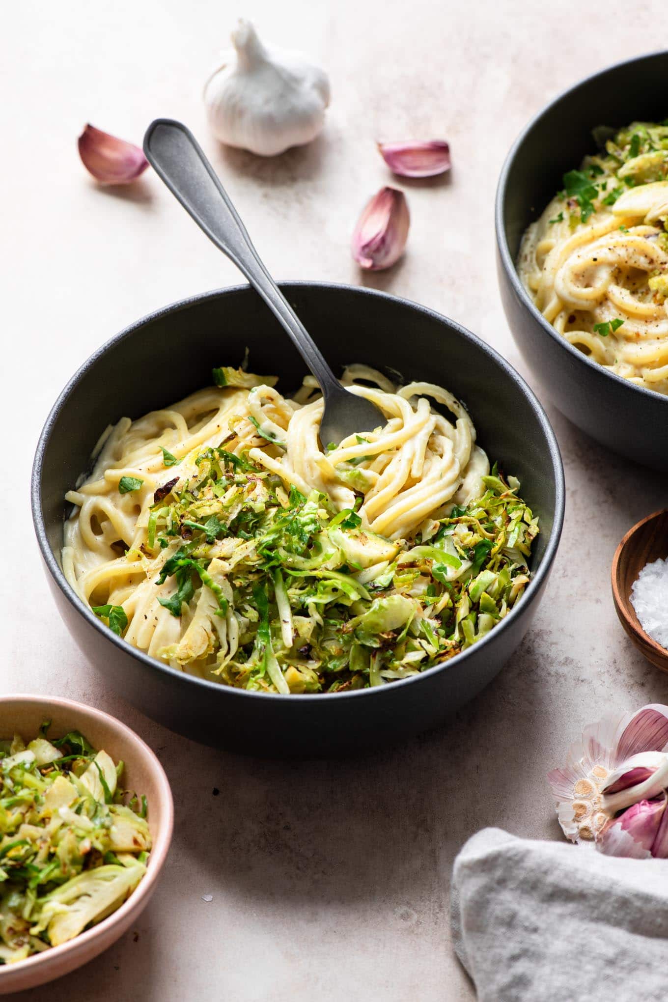 vegan creamy pasta topped with shaved brussels sprouts served in bowls