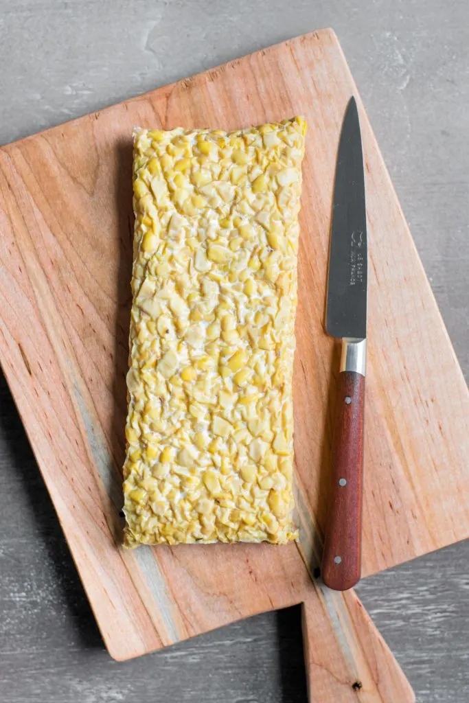 a block of tempeh on a cutting board