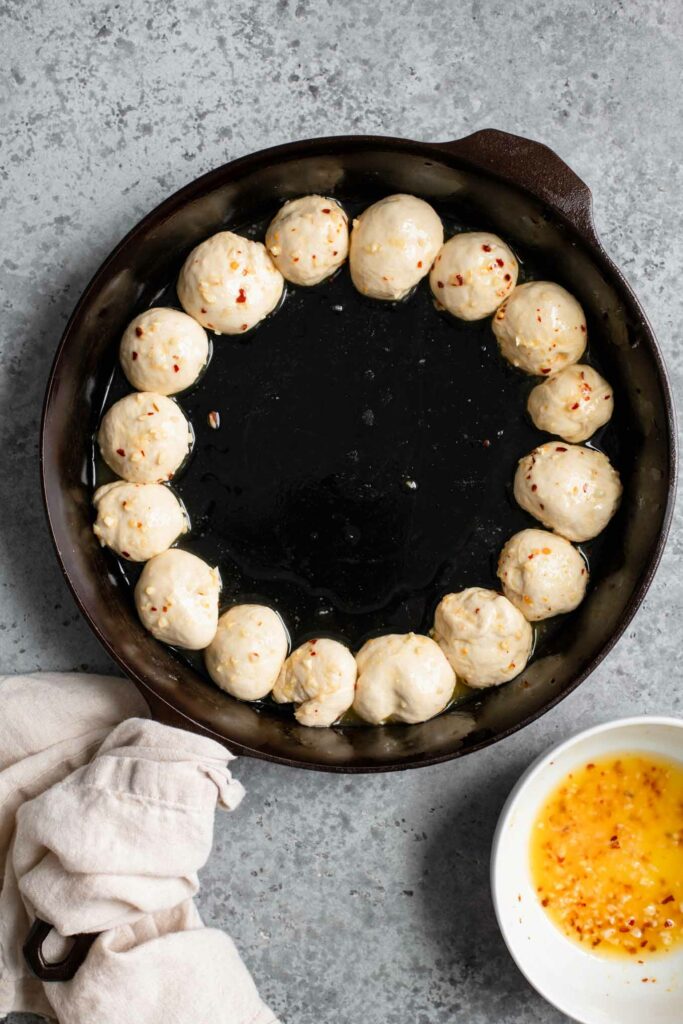 dough balls dipped in garlic butter and arranged around edge of skillet