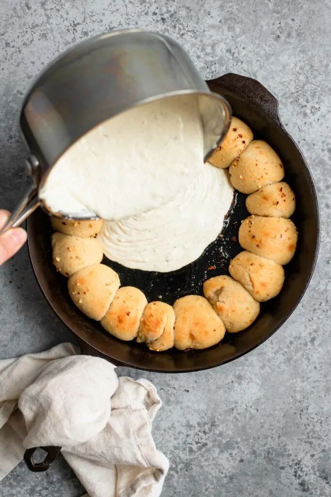 pouring dip from pot into center of skillet