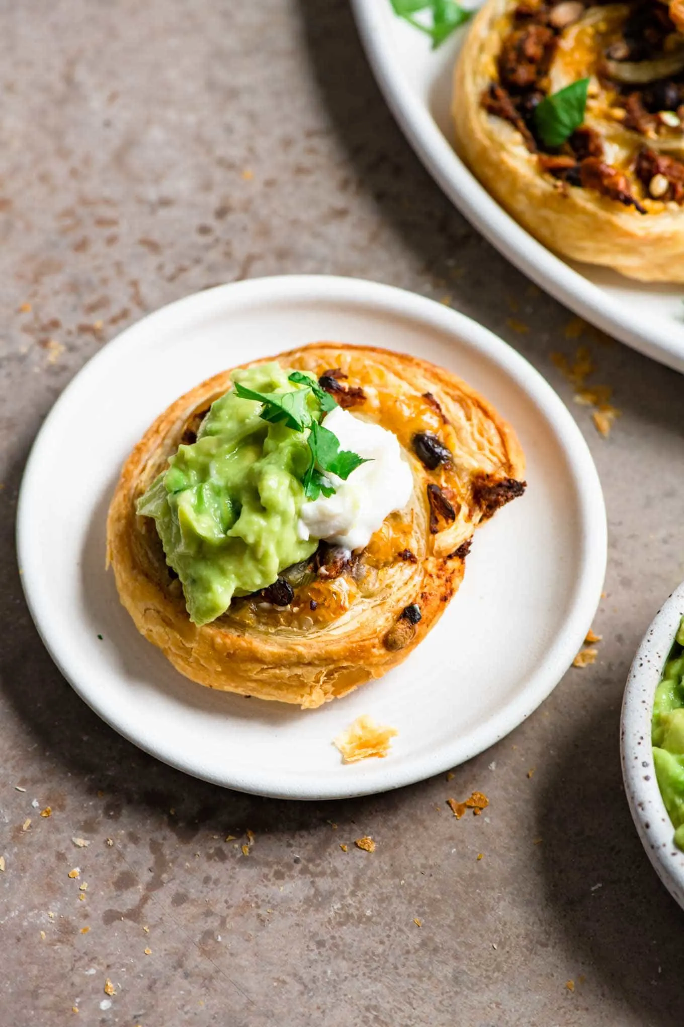 pinwheel topped with guacamole and vegan sour cream